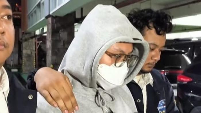 UJARAN KEBENCIAN -  Streamer Resbob tiba di Bandara Soekarno-Hatta, Kota Tangerang, Senin (15/12/2025). Ia tiba dengan pengawalan ketat dari pihak kepolisian.