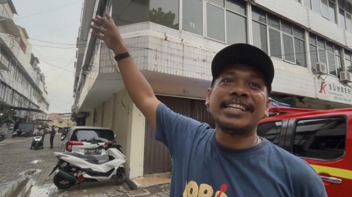 KEBAKARAN - Rian (38), sekuriti ruko perkantoran Cempaka Putih Baru. Rian turut membantu mengevakuasi setidaknya 15 karyawan yang terjebak di lantai atas gedung perkantoran kawasan Cempaka Putih, Kemayoran, Jakarta Pusat, Selasa (9/12/2025).