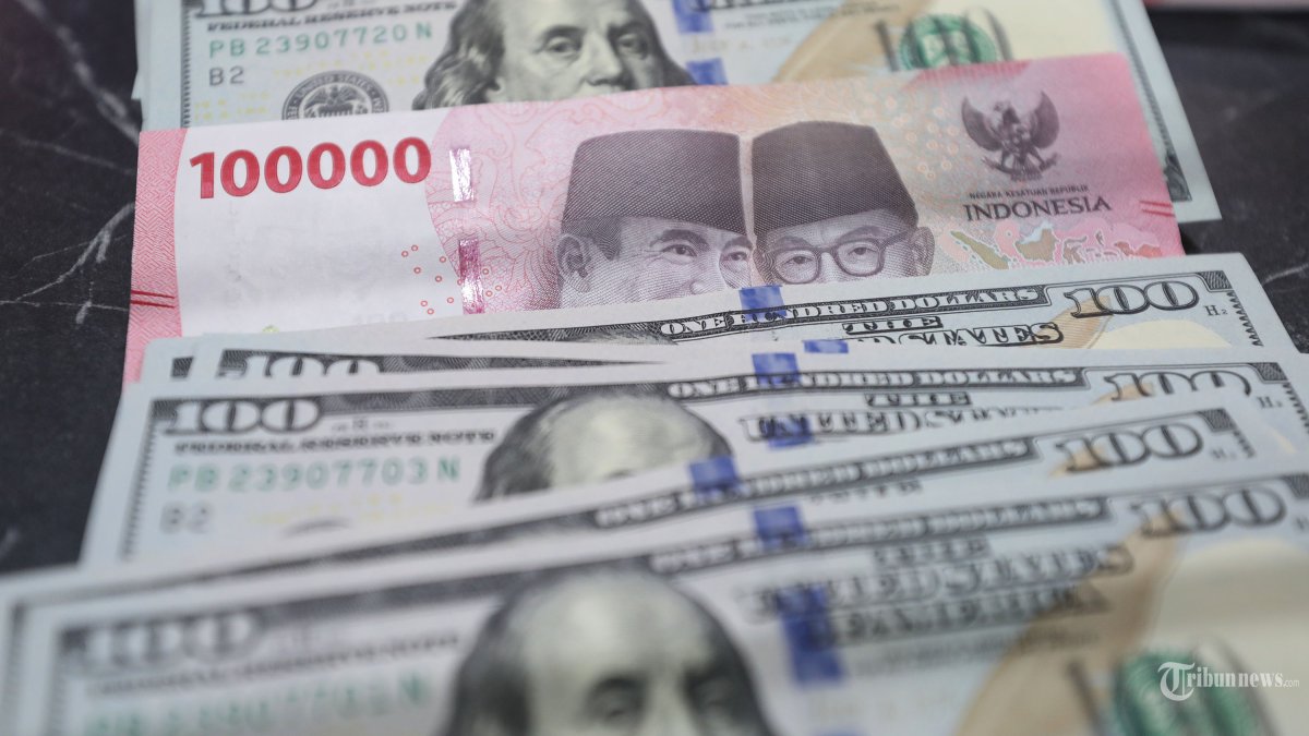 RUPIAH MENGUAT - Uang rupiah diantara dolar AS di money changer DolarAsia, Jakarta Selatan, Selasa (27/1/2026). Nilai tukar (kurs) rupiah terhadap dolar Amerika Serikat (AS) ditutup di level Rp16.768 per USD. Mata uang Indonesia menguat 14 poin atau setara 0,08 persen dari posisi Rp16.782 per USD pada penutupan perdagangan hari sebelumnya. Tribunnews/Jeprima