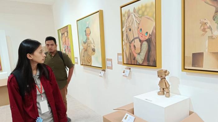 MEDIUM KARDUS - Seniman Faisal Darmawan menunjukkan karya karakter Carthea berbahan kardus dalam sebuah pameran. Melalui medium yang kerap dianggap sebagai benda sekali pakai, ia menghadirkan pesan tentang kenangan, harapan, dan perjalanan hidup. Bagi Faisal, kardus bukan sekadar limbah, melainkan simbol yang menemani manusia saat memulai babak baru kehidupan. TRIBUNNEWS/Eko Sutriyanto