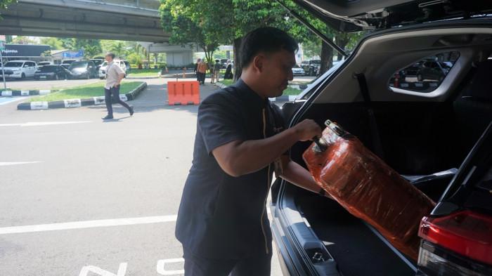 Sigit Aji menaikkan koper pelanggan Blue Bird