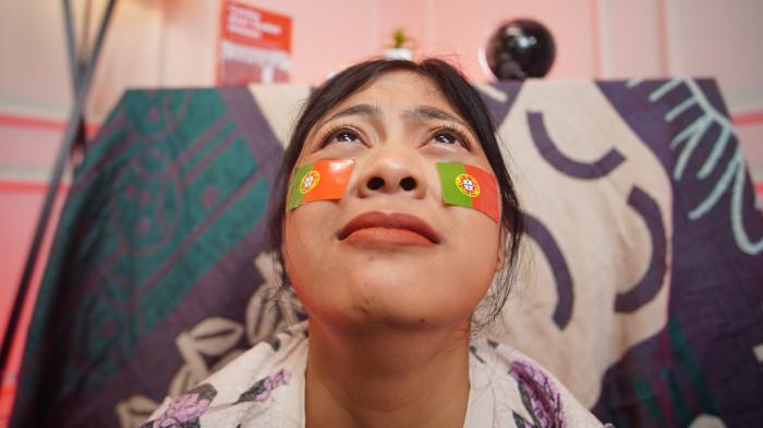 Wanita asal Solo mengenakan stiker Portugal di wajah sebagai bentuk dukungan dalam Piala Dunia 2026, di Kota Solo, Jawa Tengah, Senin (16/6/2026).