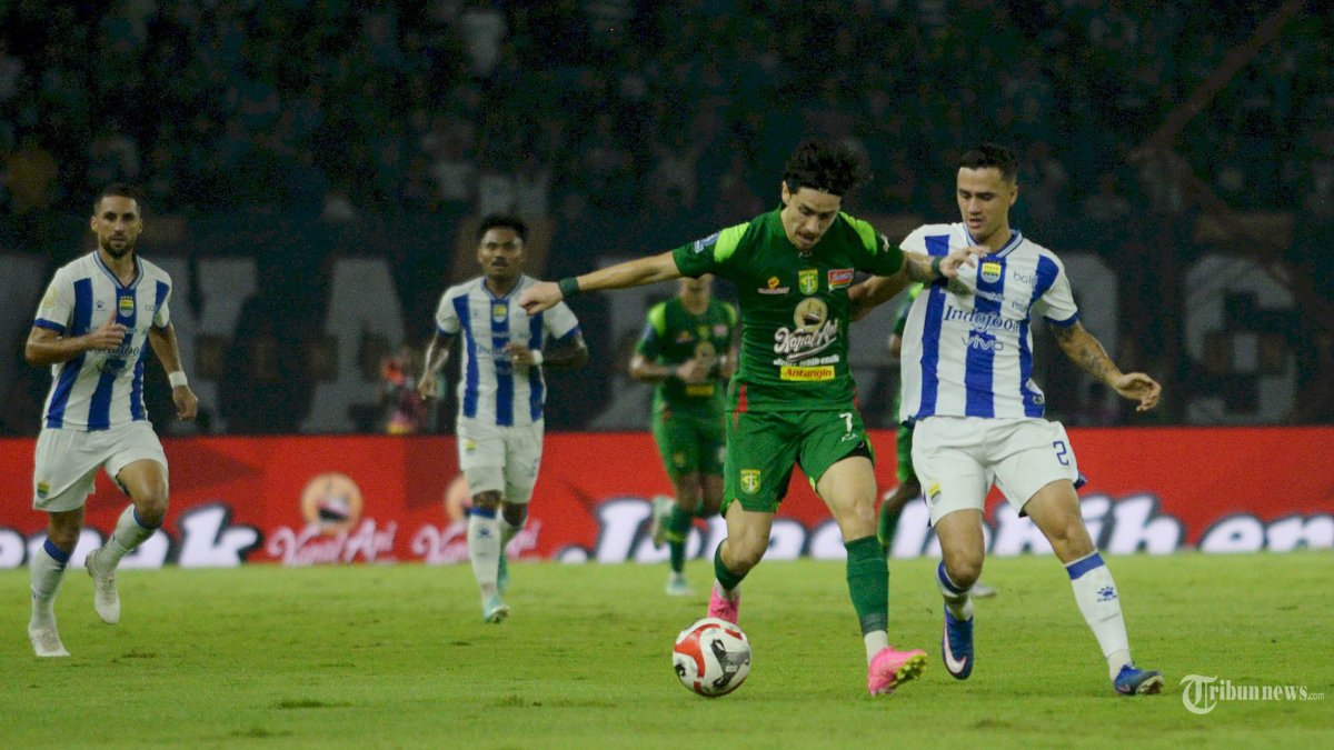 BERAKHIR IMBANG - Pemain Persebaya Rivera (dua kanan) berebut bola dengan pemain Persib bandung Reijnders (kanan) pada laga yang berlangsung di Stadion Gelora Bung Tomo (GBT) Surabaya, Senin (2/3/2026) malam. Pada akhir pertandingan BRI Super League pekan ke 24 ini tim tuan tamu Persib Bandung berhasil menahan imbang tim tuan rumah Persebaya dengan skor akhir 2-2. (SURYA/HABIBUR ROHMAN)