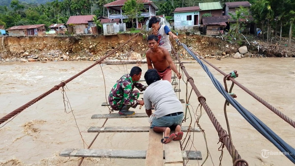 Prajurit TNI dari Posramil Darul Hasanah jajaran Kodim 0108/Aceh Tenggara bersama warga masyarakat melaksanakan perbaikan jembatan gantung di Desa Buntul Kendawi, Kecamatan Darul Hasanah, Kabupaten Aceh Tenggara, Senin (15/12/2025). 