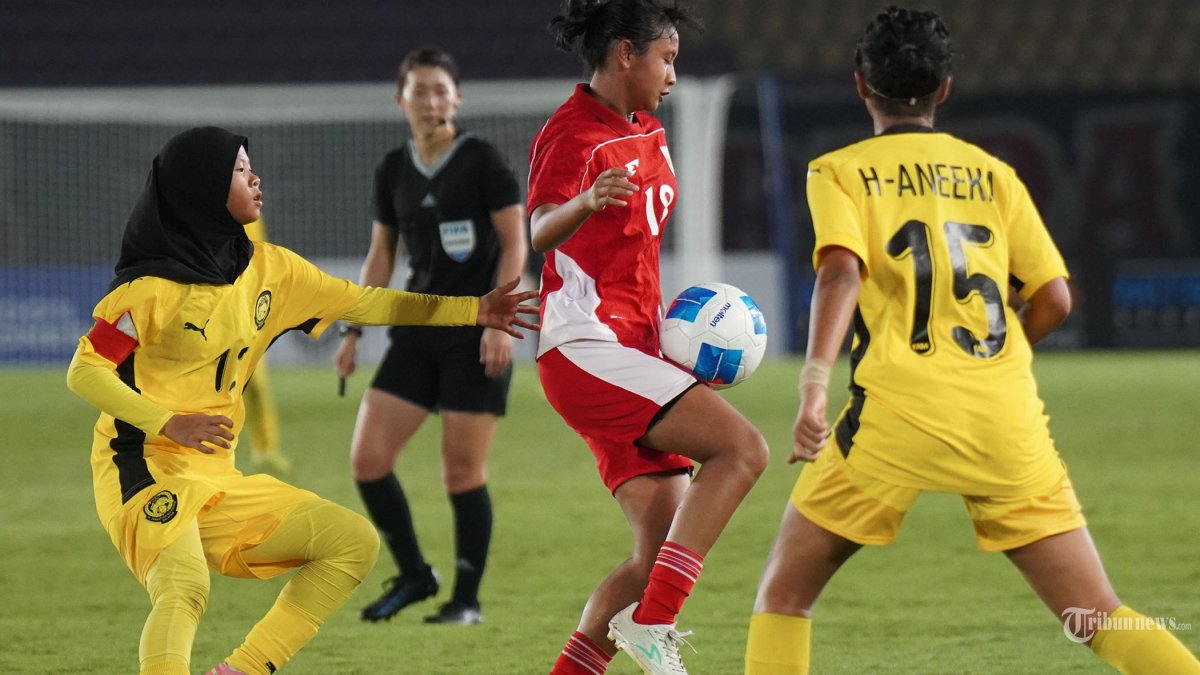 AFF U16 PUTRI - Pesepak bola Timnas Putri U16 Indonesia, Vivi Vera Fernanda (tengah) mengontrol bola saat melawan pesepak bola putri U16 Malaysia dalam pertandingan Piala AFF Putri U16 di Stadion Manahan, Solo, Sabtu (24/8/2025) malam. Timnas Putri U16 Indonesia menang dengan skor 3-1 atas Malaysia dan melaju ke babak semifinal. Tribun Solo/Muhammad Nursina
