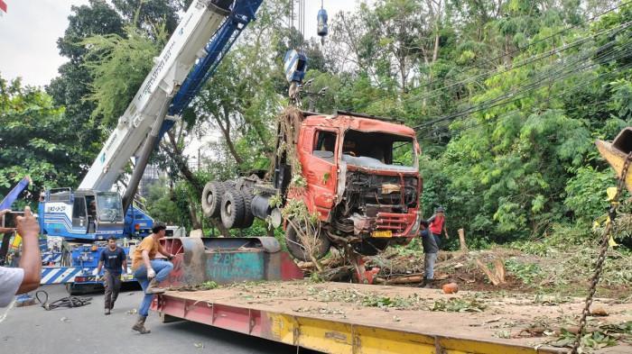 EVAKUASI TRUK - Truk berwarna merah yang membawa alat berat Rotary Drilling Rig yang digunakan untuk mengebor dan memasang paku bumi kelas 70 ton merek XCMG saat dievakuasi, Senin (11/8/2025).
