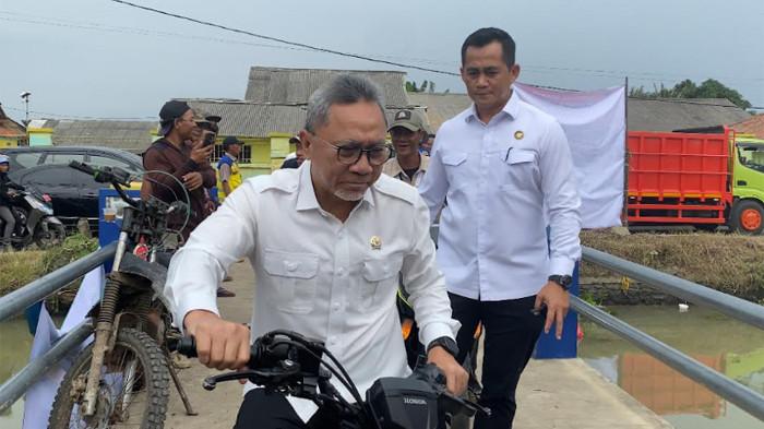 ZULHAS NAIK MOTOR - Momen Menko Pangan Zulkifli Hasan alias Zulhas kendarai motor matic saat menyusuri kemacetan di Cilebar, Karawang, Jawa Barat, Rabu (7/1/2026). (Igman Ibrahim)