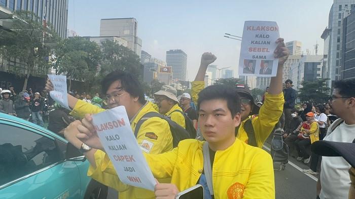 AKSI DEMO - Momen mahasiswa Universitas Indonesia (UI) berjaket almamater kuning berorasi sambil membentangkan kertas bertuliskan pesan protes terkait pajak mahal dan kekesalan terhadap pemerintah. Mereka mengajak pengendara yang melintas untuk membunyikan klakson.