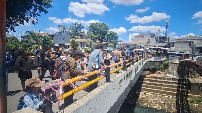 AKSI SOLIDARITAS – Sejumlah aktivis dari gabungan masyarakat sipil mengikat pita pink di sisi Jembatan Jalan Talang, Salemba, Jakarta Pusat, Minggu (12/4/2026), lokasi penyiraman air keras terhadap aktivis KontraS Andrie Yunus. Aksi ini menjadi simbol solidaritas sekaligus aspirasi tuntutan atas kejahatan yang menimpa Andrie.