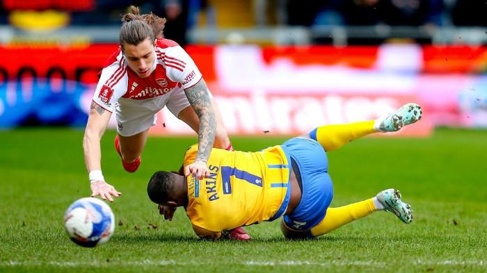 BERDUEL - Duel antara Riccardo Calafiori (kiri atas) dengan Lucas Akins pada pertandingan putaran 5 Piala FA 2025/2026 antara Mansfield vs Arsenal di Field Mill Stadium, Sabtu (7/3) malam WIB.