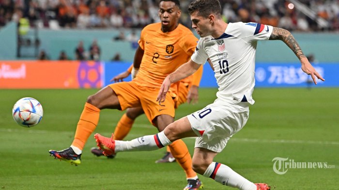 Bek Belanda Jurrien Timber (kiri) berebut bola dengan penyerang AS Christian Pulisic selama pertandingan sepak bola babak 16 besar Piala Dunia Qatar 2022 antara Belanda dan AS di Stadion Internasional Khalifa di Doha. Sabtu (3 Desember 2022). (Alberto PIZZOLI/AFP)