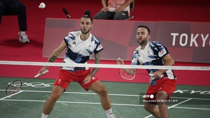 Ben Lane (kanan) dari Inggris melakukan pukulan dalam pertandingan penyisihan grup bulu tangkis ganda putra dengan pasangannya Sean Vendy dari Inggris melawan Kevin Sanjaya Sukamuljo dan Marcus Fernaldi Gideon dari Indonesia selama Olimpiade Tokyo 2020 di Musashino Forest Sports Plaza di Tokyo pada 24 Juli 2021 .