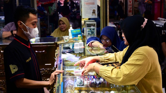 Sejumlah warga berburu perhiasan dimusim pernikahan pada bulan Dzulhijjah 2022 ditoko emas Bulan Purnama, Pasar Besar Malang, Selasa, (12/7/2022). Momen musim nikah membuat toko-toko emas menjadi sasaran warga yang ingin berburu mas kawin perhiasan emas. Cincin, kalung, dan gelang menjadi buruan utama pada musim nikah. TRIBUN JATIM/PURWANTO