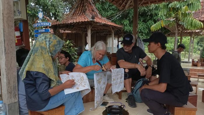 BELAJAR MEMBATIK - Jiel, wisatawan asal Kanada bersama sang suami, Torn belajar membatik di Sekretariat Desa Wukirsari, Jalan Giriloyo, Kapanewon Imogiri, Kabupaten Bantul, Yogyakarta, Senin (20/10/2025). Mereka berkunjung ke Kampung Batik Giriloyo, bagian dari Desa Wisata Wukirsari, sebuah sentra kerajinan batik tulis tradisional tertua dan terbaik di Bantul.
