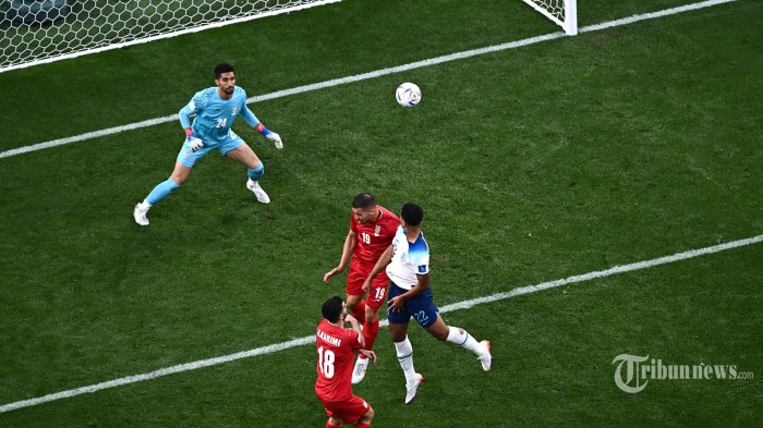AKSI - Gelandang Inggris Jude Bellingham (kanan) mencetak gol pertama timnya selama pertandingan sepak bola Grup B Piala Dunia 2022 Qatar antara Inggris dan Iran di Stadion Internasional Khalifa di Doha. Senin (21/11/2022). (Jewel SAMAD/ AFP) (Foto arsip)