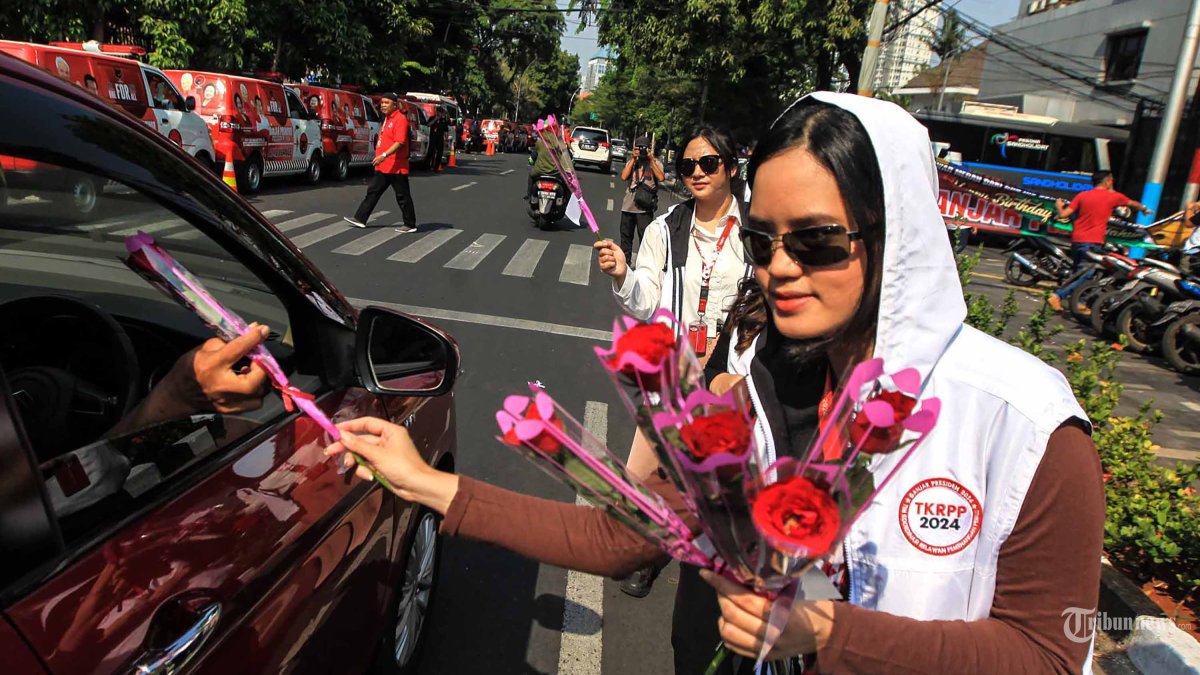 Sejumlah relawan membagikan bunga mawar kepada pengendara di Jl. Diponegoro, Jakarta, Sabtu (28/10/2023). Kegiatan yang diselenggarakan oleh nakes yang terdiri dari dokter dan perawat ini dalam merayakan ulang tahun Ganjar Pranowo ke-55 tahun sekaligus konsolidasi yang juga bentuk dukungan terhadap Ganjar Pranowo dan Mahfud MD sebagai bakal calon presiden dan bakal calon wakil presiden 2024 yang diusung oleh PDI Perjuangan, PPP, Hanura, Perindo. TRIBUNNEWS/HERUDIN