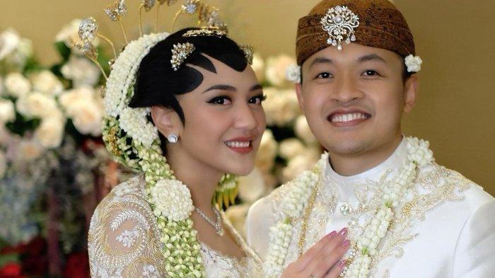 Guinandra Jatikusumo tampil serasi dengan Putri Tanjung dalam balutan beskap putih.