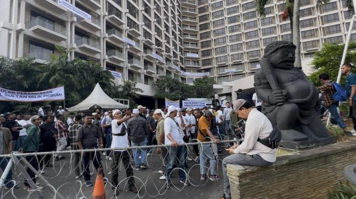 Suasana kerumunan massa yang memadati pelataran depan Hotel Sultan, Jakarta, untuk menolak proses eksekusi lahan. Tampak kawat berduri dibentangkan sebagai barikade pengamanan, serta sejumlah spanduk penolakan yang dipasang di area lobi dan balkon hotel.