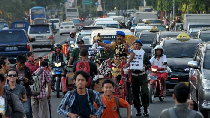 Sang Kopral Berkostum Gatotkaca Naik Becak Bagi-Bagi Takjil