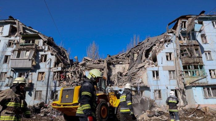 Tim penyelamat Ukraina bekerja di gedung tempat tinggal berlantai lima yang hancur setelah serangan rudal di Zaporizhzhia pada 2 Maret 2023, di tengah invasi Rusia ke Ukraina. Serangan Rusia di sebuah blok apartemen di kota Zaporizhzhia, Ukraina selatan telah menewaskan sedikitnya tiga orang, kata pihak berwenang setempat pada 2 Maret, saat operasi pencarian sedang berlangsung. Katerina Klochko / AFP