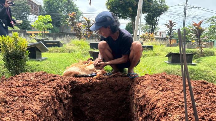 LIANG KUBUR ALVARO - Gundukan tanah dan sebuah liang lahat telah nampak di Tanah Wakaf Masjid Jami Al-Muflihun, Bintaro, Pesanggrahan, Jakarta Selatan, Rabu siang (26/11/2025). Liang kubur ini akan menjadi rumah peristirahatan abadi bagi almarhum Alvaro Kiano Nugroho (6).