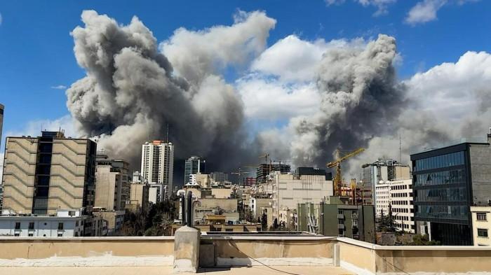SERANGAN KE IRAN - Kepulan asap tebal terlihat menjulang di atas Iran pada hari Minggu (1/3/2026), hari kedua operasi tempur 'berskala besar' AS dan Israel.