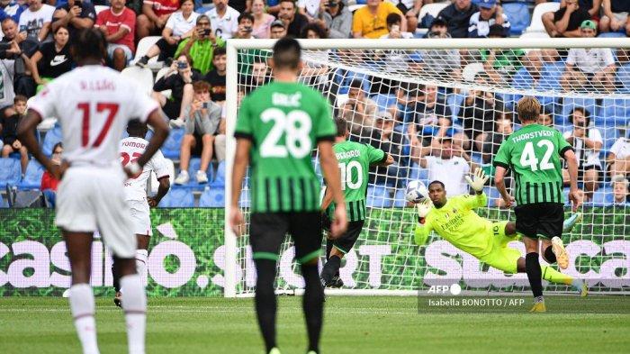 Kiper AC Milan, Mike Maignan (Belakang) menangkis tendangan penalti pemain depan Sassuolo Domenico Berardi (Kiri Belakang) selama pertandingan sepak bola Serie A Italia, pada 30 Agustus 2022 di stadion Mapei.