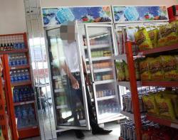 Panasnya Cuaca Kota Semarang Membuat Karyawan Minimarket Ini Ngadem di Kulkas