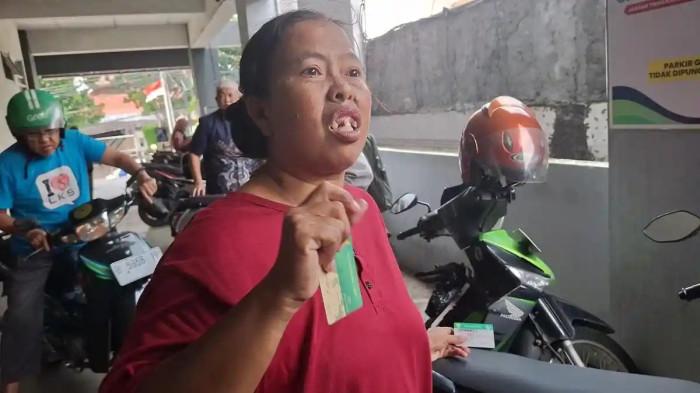MENDADAK NONAKTIF - Wajah Mujiati (40) tampak kebingungan saat ditemui di kantor layanan BPJS Kesehatan, Semarang, Kamis (5/2/2026). Bersama suaminya, Subur (65), warga Kelurahan Siwalan, Kecamatan Gayamsari, harus menunda rencana berobat karena kepesertaan BPJS Kesehatan Penerima Bantuan Iuran Jaminan Kesehatan (PBI JK) miliknya mendadak nonaktif.