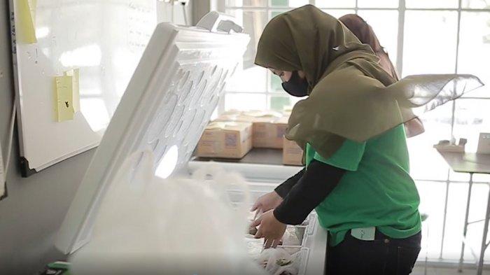 Pekerja memeriksa produk frozen food di warehouse Tukoni