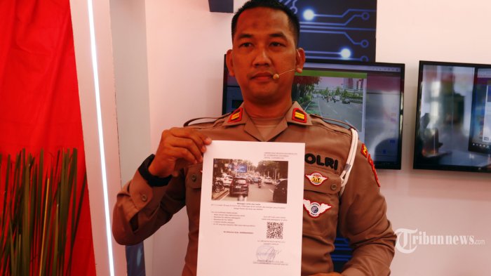Petugas menunjukkan contoh surat tilang dari sistem tilang elektronik (ETLE) mobile yang diluncurkan di Lapangan Presisi Ditlantas Polda Metro Jaya, Jakarta Selatan, Selasa (13/12/2022). Polda Metro Jaya meluncurkan 11 kendaraan patroli khusus yang dilengkapi ETLE mobile untuk bertugas di ruas-ruas jalan raya se-DKI Jakarta dan Tangerang Selatan yang tidak terpasang kamera ETLE statis. WARTA KOTA/YULIANTO