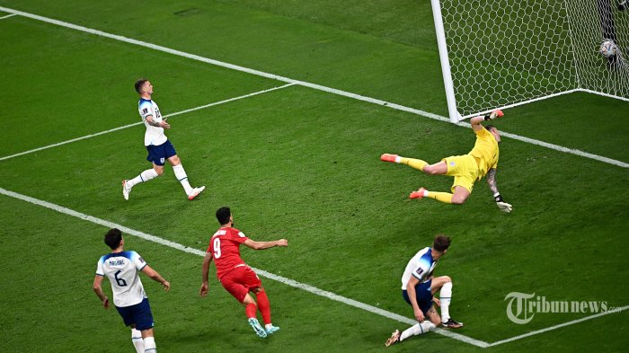 IRAN - Penyerang Iran Mehdi Taremi (C) mencetak gol melewati kiper Inggris Jordan Pickford selama pertandingan sepak bola Grup B Piala Dunia Qatar 2022 antara Inggris dan Iran di Stadion Internasional Khalifa di Doha pada 21 November 2022. (Anne-Christine) POUJOULAT / AFP) (Foto arsip)