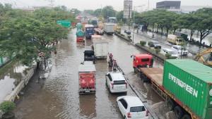 Pengendara-mendorong-motor-yang-mogok-akibat-banjir-di-Jalan-Kaligawe-Semarang-Timur.jpg