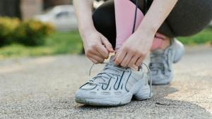 Seorang-pelari-mengikat-tali-sepatu-sebelum-memulai-latihan-di-ruang-terbuka.jpg