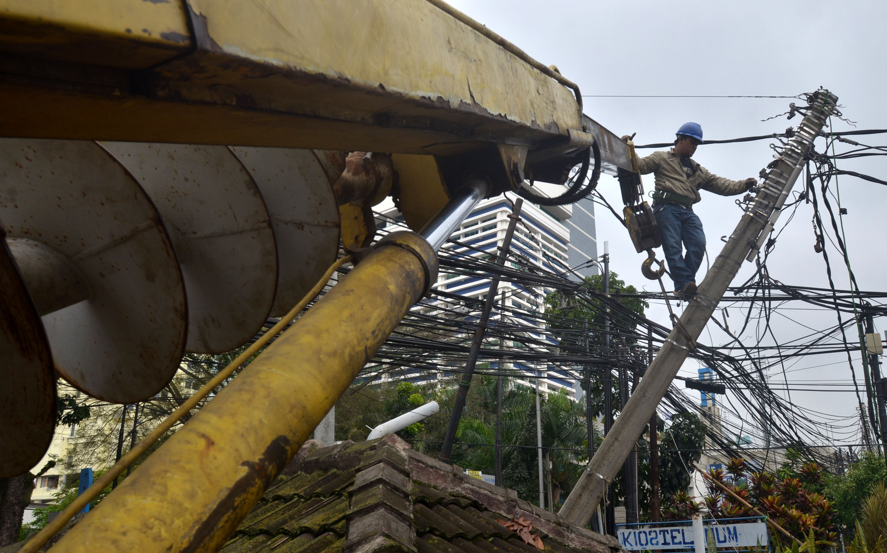 20140124_120206_petugas-pln-membongkar-tiang-listrik-miring.jpg