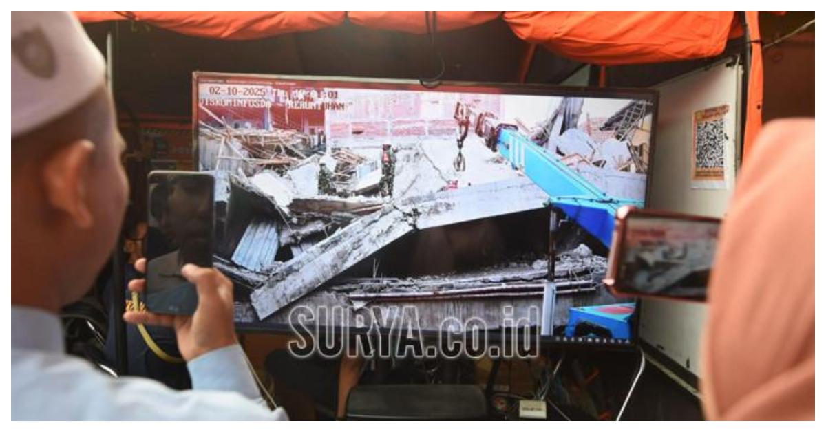 PONPES AMBRUK - Keluarga memantau evakuasi korban bangunan runtuh di ponpes Al Khoziny, Buduran, Sidoarjo dari layar yang disediakan di posko Basarnas, Kamis (2/10/2025). Evakuasi korban bangunan runtuh mulai menggunakan alat berat.