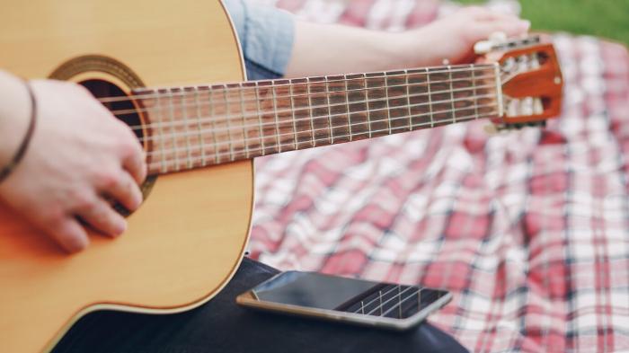 Ilustrasi-seseorang-menyimak-chord-gitar-di-ponsel.jpg