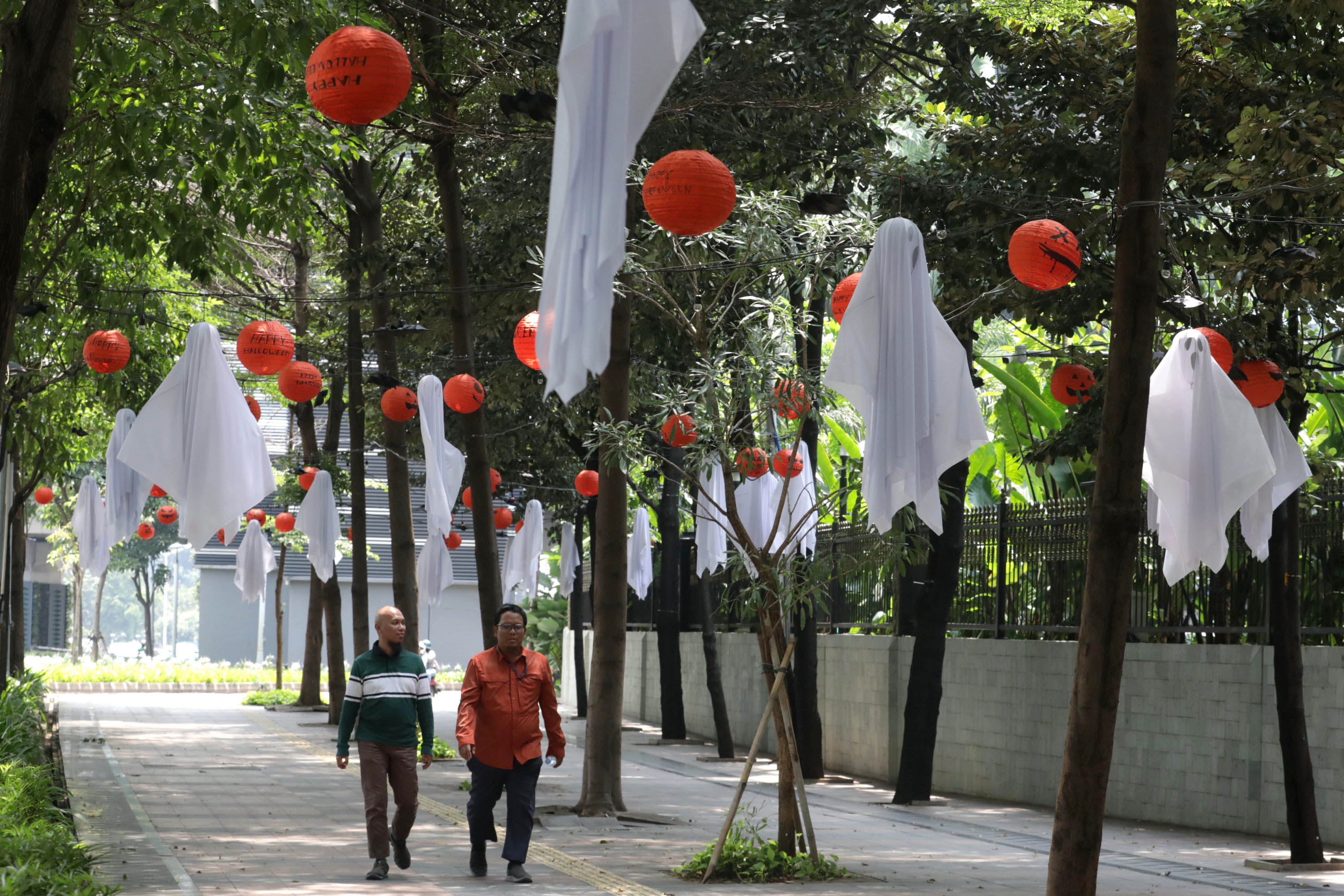 HIASAN HALLOWEEN - Warga melintasi pedestrian yang berhiaskan Halloween di kawasan Jalan Jenderal Sudirman, Jakarta, Jumat (30/10/2025). Hiasan lampion tersebut dipasang untuk menyambut perayaan Halloween yang identik dengan nuansa menyeramkan serta berbagai hiasan dan kostum unik setiap 31 Oktober. Selain menambah suasana perayaan, hiasan ini juga mempercantik area pedestrian di kawasan pusat kota Jakarta. TRIBUNNEWS/IRWAN RISMAWAN