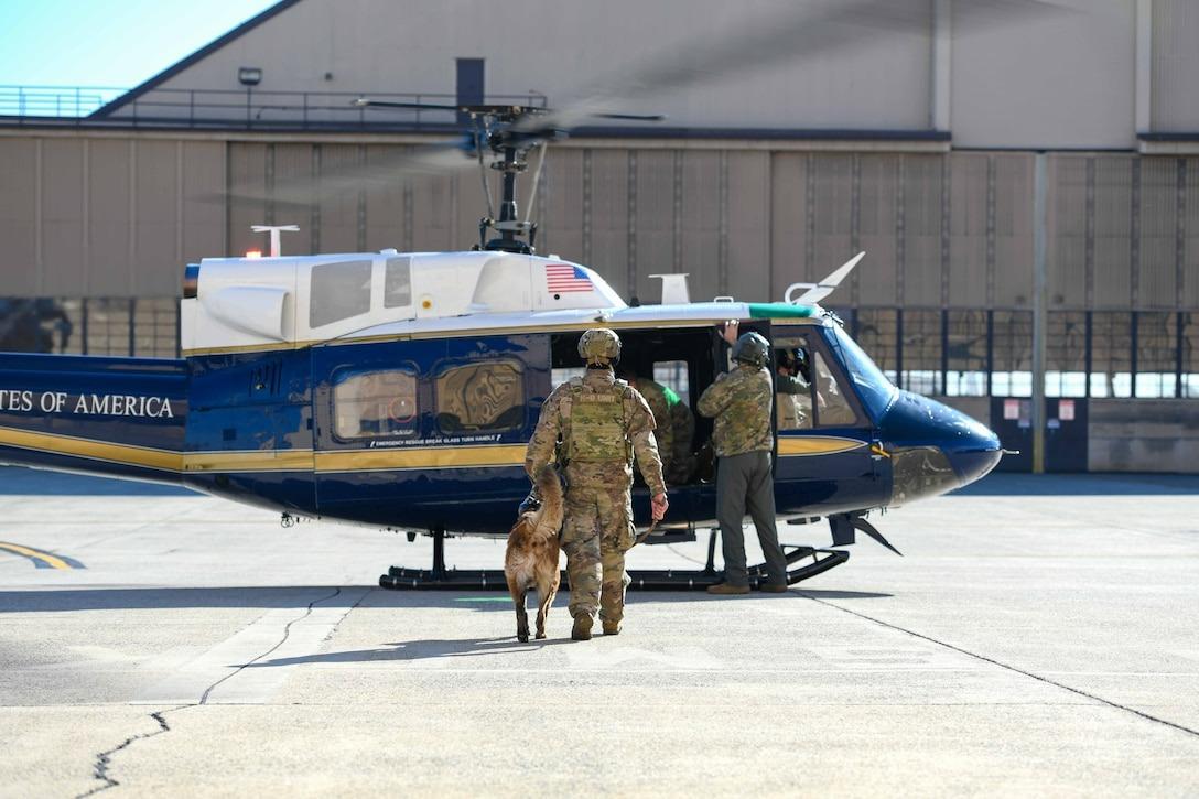 PANGKALAN UDARA AMERIKA - Foto yang dirilis Pangkalan Gabungan Andrews di situs resminya, menunjukkan seorang prajurit Angkatan Udara AS dan anjing pelacak militer bersiap untuk naik ke helikopter UH-1N Huey Angkatan Udara AS yang ditugaskan ke Skuadron Helikopter ke-1 di Pangkalan Gabungan Andrews, Maryland, 12 November 2025. (jba.af.mil)