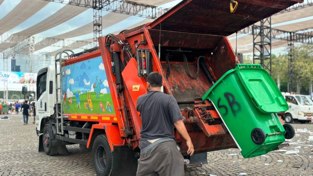 Petugas-membersihkan-tumpukan-sampah-ke-dalam-truk-hidrolik-di-Monas-usai-Hari-Buruh.jpg