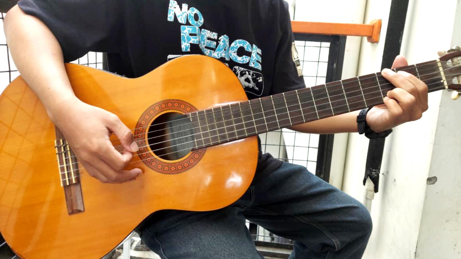Potret-seseorang-sedang-bermain-gitar-dengan-kunci-chord-dasar-mudah-dimainkan.jpg