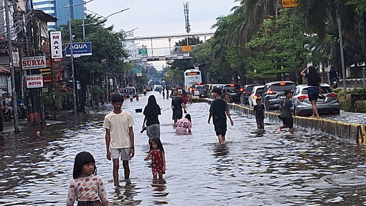 anak-bermain-di-genangan-banjir-Jalan-Gunung-Sahari-depan-Mangga-Dua-Square-Jakarta.jpg