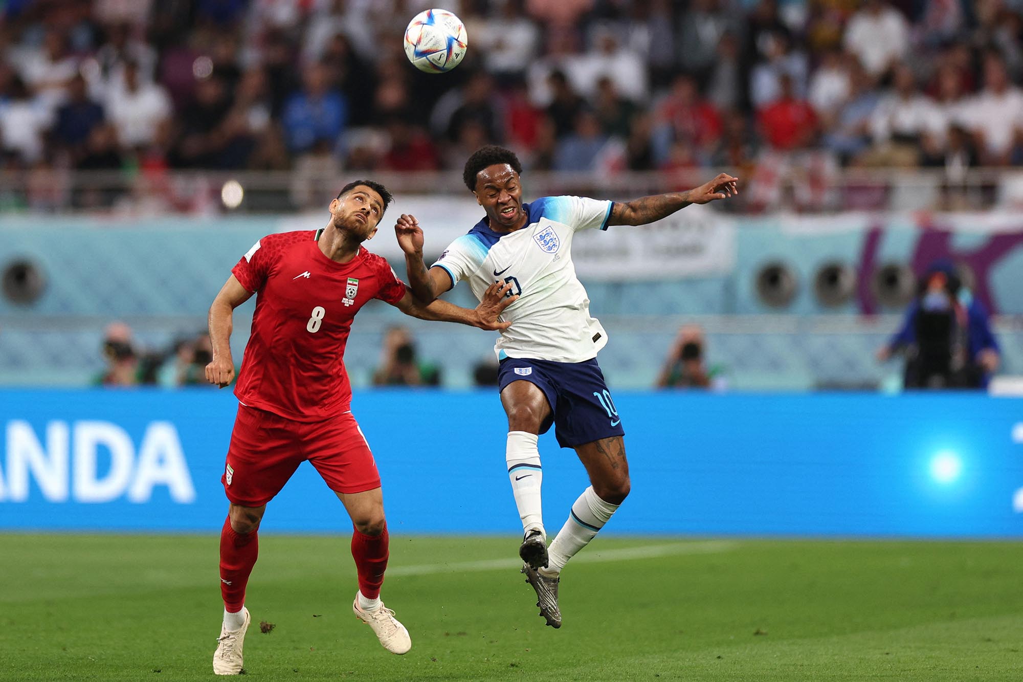 Bek Iran #08 Morteza Pouraliganji dan penyerang Inggris #10 Raheem Sterling memperebutkan bola selama pertandingan sepak bola Grup B Piala Dunia Qatar 2022 antara Inggris dan Iran di Stadion Internasional Khalifa di Doha pada 21 November 2022. (Foto oleh Adrian DENNIS / AFP)