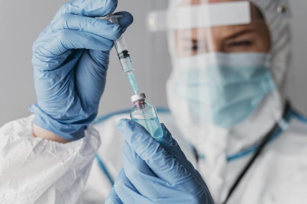 ilustrasi-vaksinasi-dokter-pegang-suntikan-vaksin.jpg