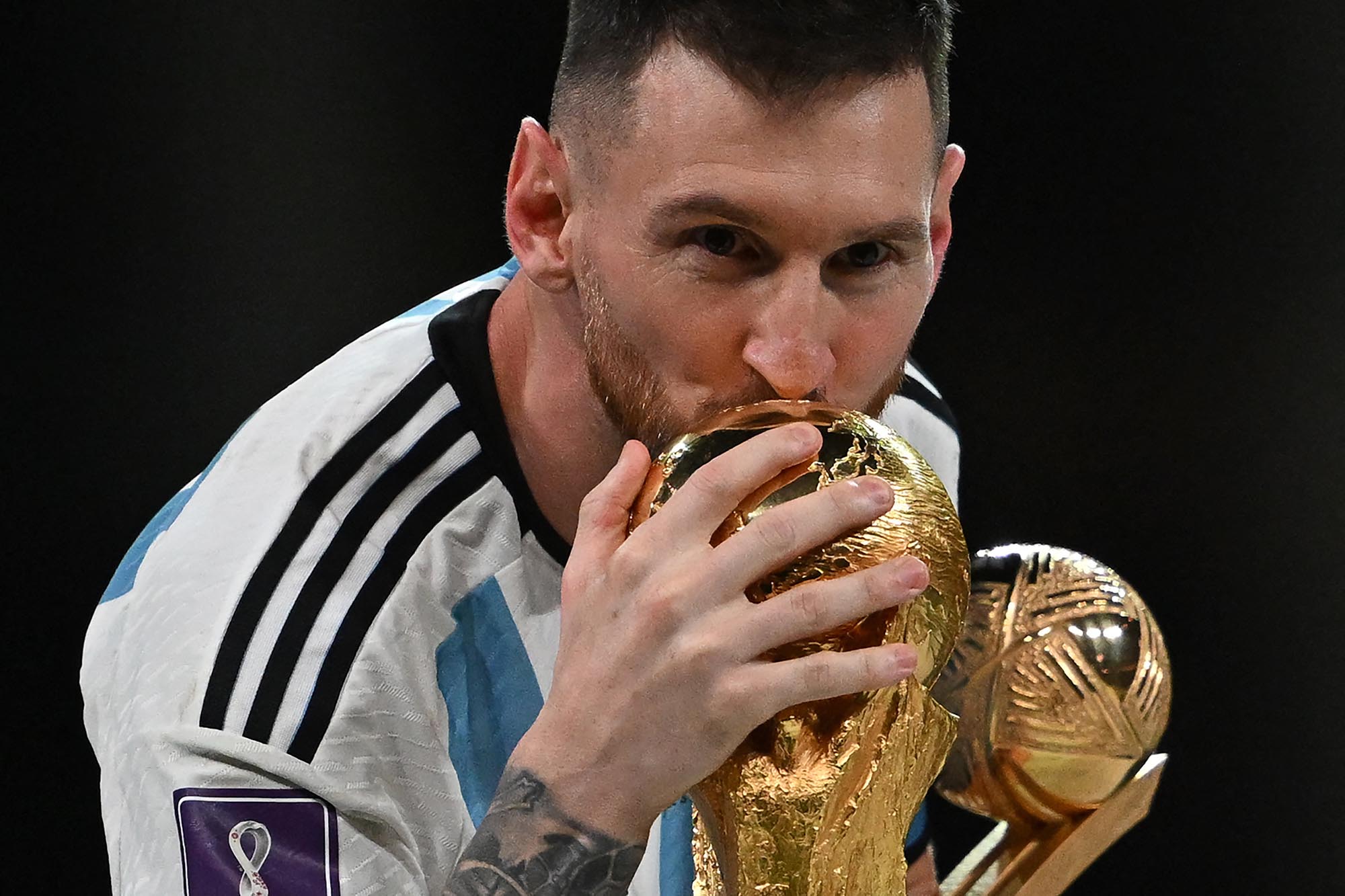 lionel-messi-mencium-trofi-piala-dunia-2022_20221219_015528.jpg
