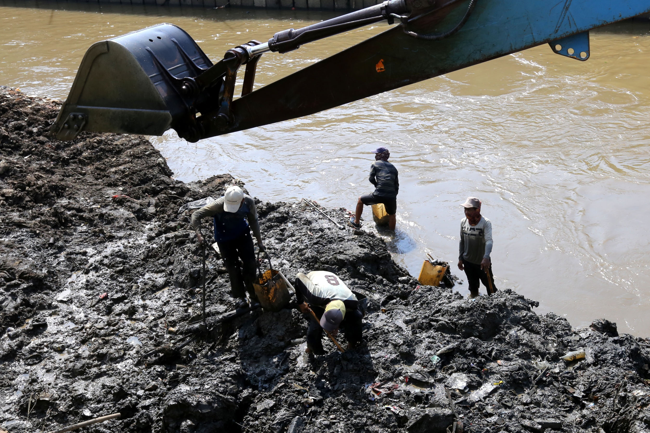 mencari-barang-bekas-di-tumpukan-lumpur-sungai-ciliwung_20220523_174239.jpg