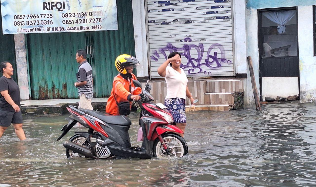 pengendara-menuntun-sepeda-motor-mogok-usai-melintasi-genangan-banjir-di-Pademangan.jpg