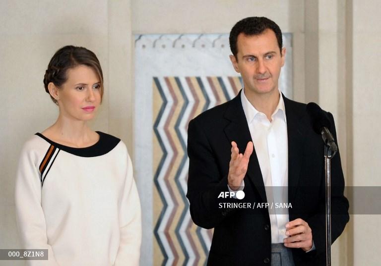 BASHAR AL ASSAD. - Sebuah gambar selebaran yang dirilis oleh Kantor Berita Arab Suriah (SANA) resmi menunjukkan Presiden Suriah Bashar al-Assad (kanan) berbicara di samping istrinya Asma ketika mereka menerima anggota tentara dan ibu mereka untuk merayakan Hari Ibu di ibu kota Damaskus pada bulan Maret. 21, 2016.