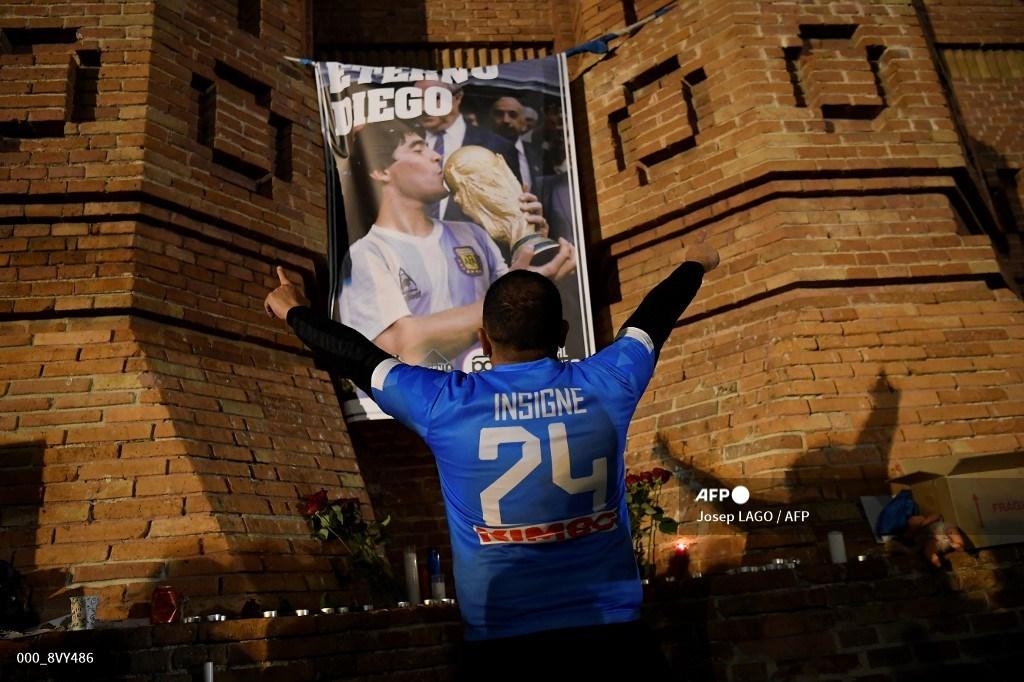 seorang-penggemar-sepak-bola-napoli-memberi-isyarat-di-depan-spanduk-bertuliskan-diego-abadi.jpg