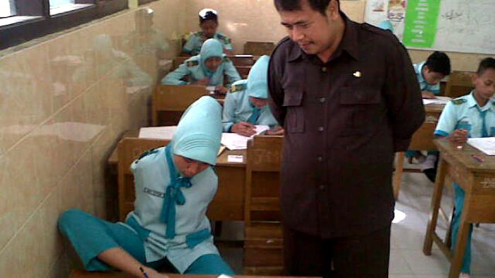 siswi-kerjakan-ujian-nasional-pakai-kaki_20150506_133442.jpg